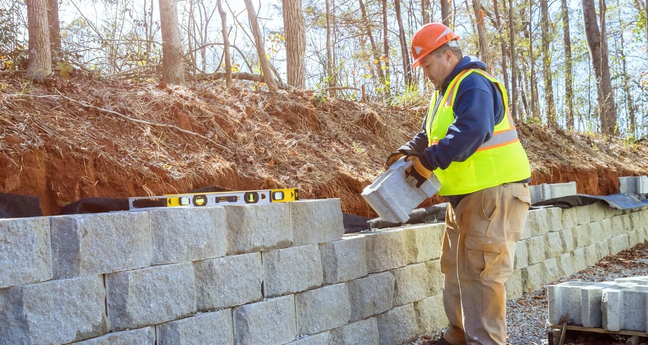 man holding a brick to build a wall